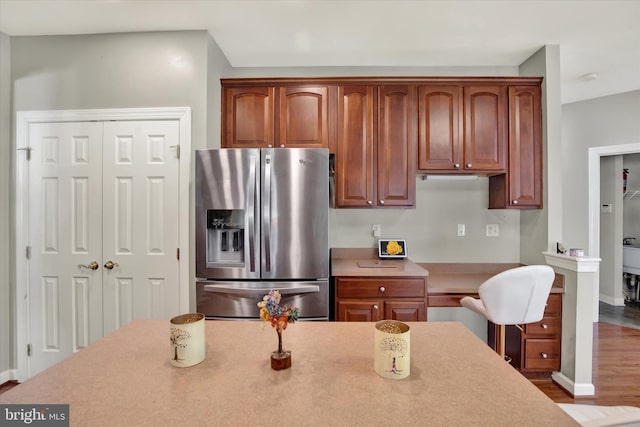 kitchen with stainless steel refrigerator with ice dispenser and hardwood / wood-style flooring