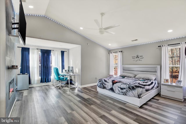 bedroom with ceiling fan, hardwood / wood-style floors, and vaulted ceiling