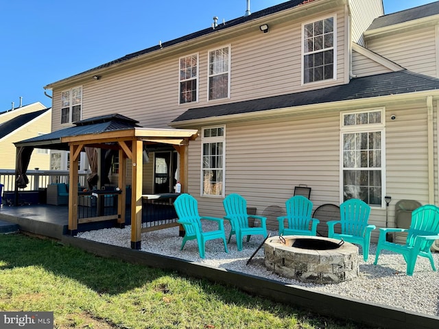 back of property featuring a gazebo and an outdoor fire pit