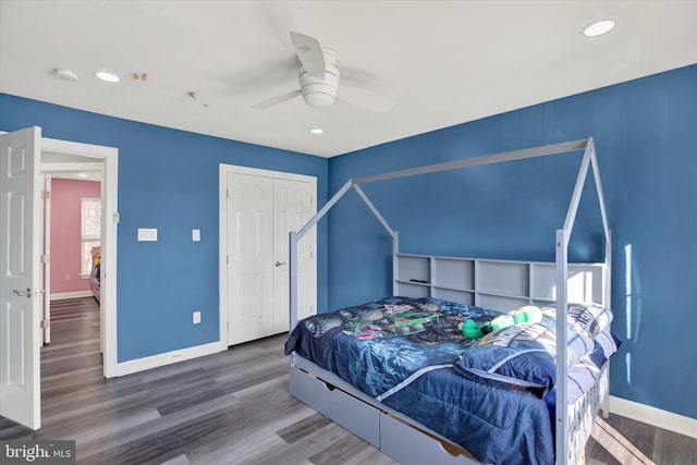 bedroom with hardwood / wood-style floors, a closet, and ceiling fan