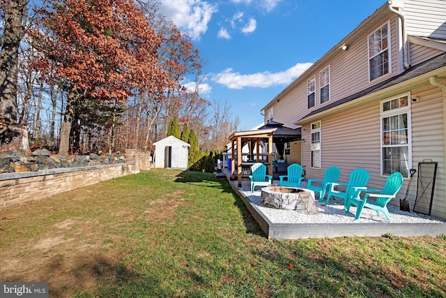 view of yard featuring a fire pit, a storage unit, and a gazebo