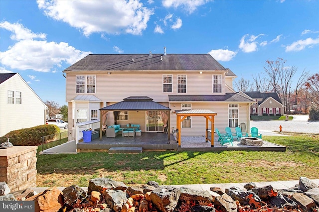 back of house featuring a gazebo, a patio, an outdoor living space with a fire pit, and a lawn