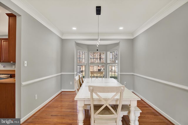 dining room with hardwood / wood-style flooring and ornamental molding