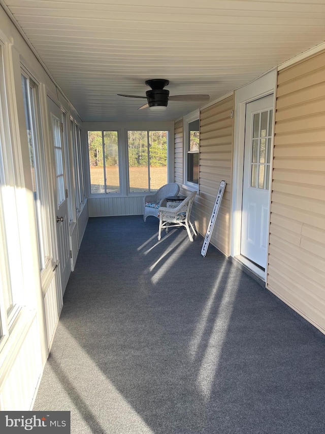 unfurnished sunroom with ceiling fan