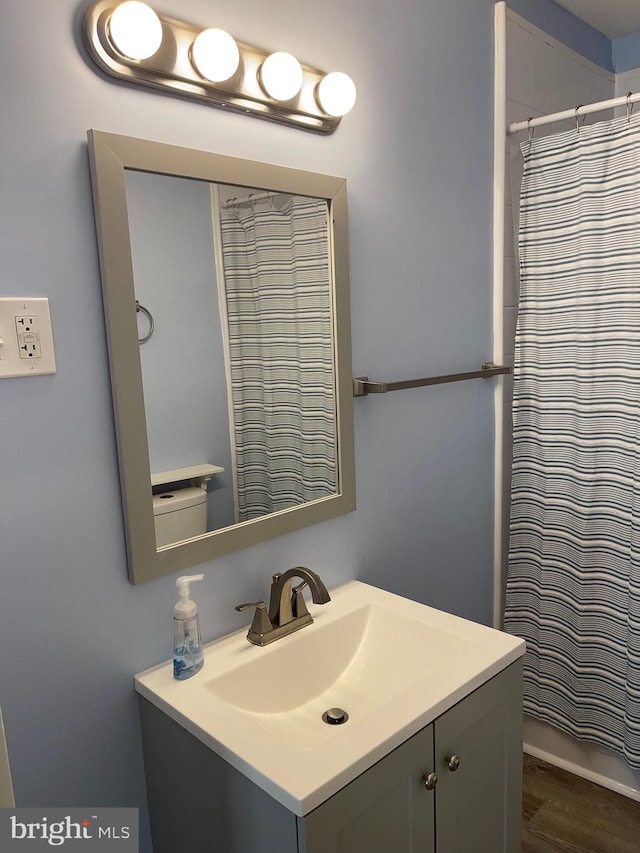 bathroom featuring a shower with shower curtain, vanity, and hardwood / wood-style flooring