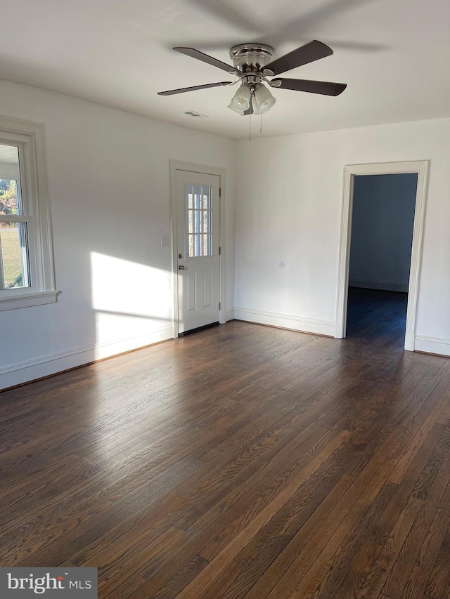 unfurnished room with ceiling fan and dark wood-type flooring