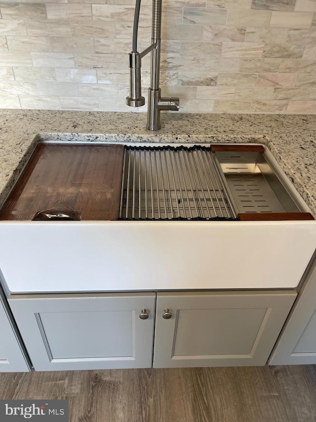 details with hardwood / wood-style floors and light stone counters