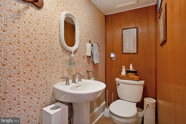 bathroom featuring toilet and wood walls