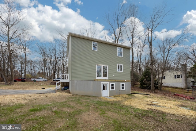 rear view of house featuring a yard