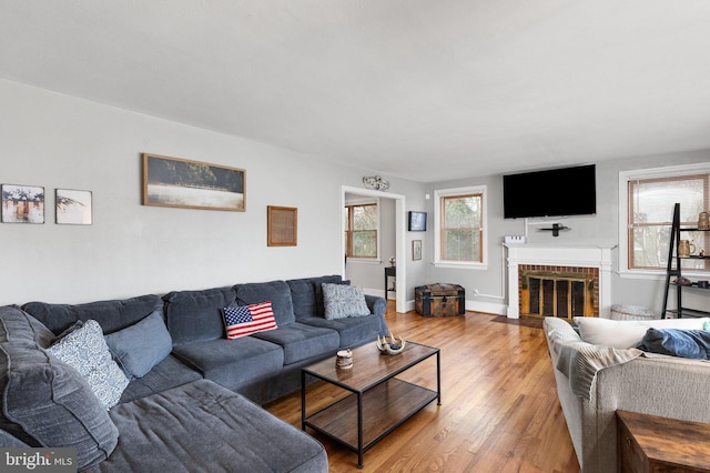 living room featuring light hardwood / wood-style floors and a brick fireplace