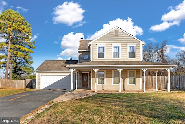 view of front of property with covered porch, a garage, and a front yard