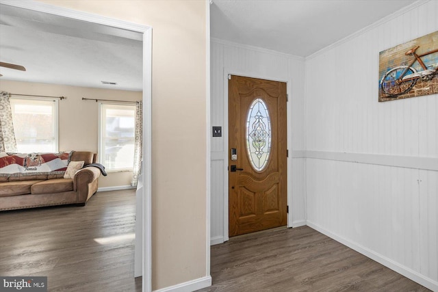 entryway with crown molding and dark wood-type flooring