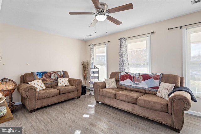 living room featuring plenty of natural light, ceiling fan, and wood-type flooring