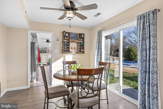 dining room with ceiling fan and dark wood-type flooring