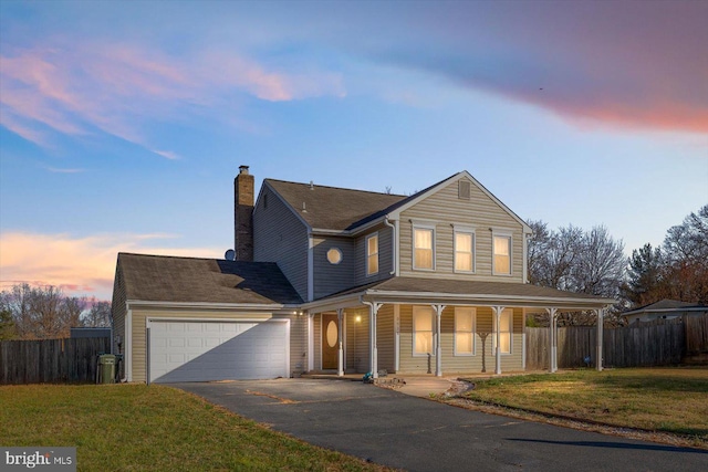 view of front of house featuring a porch, a garage, and a lawn