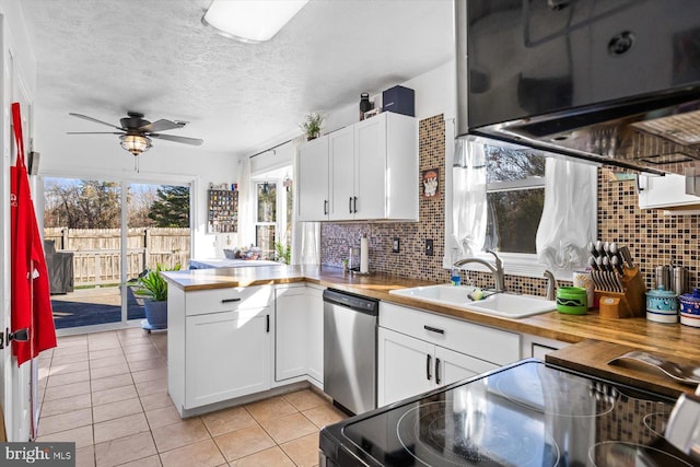 kitchen featuring tasteful backsplash, white cabinets, wooden counters, and appliances with stainless steel finishes