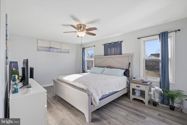 bedroom with light wood-type flooring, multiple windows, and ceiling fan