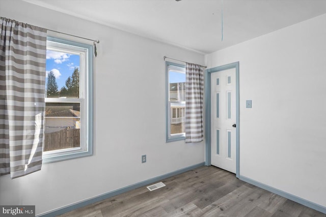 empty room with a wealth of natural light and light wood-type flooring