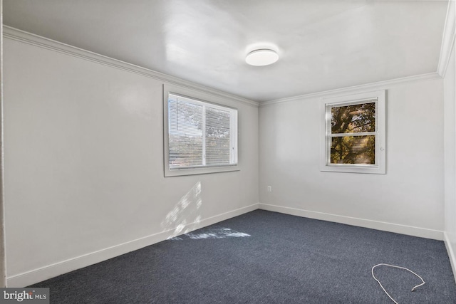 empty room featuring crown molding and dark carpet