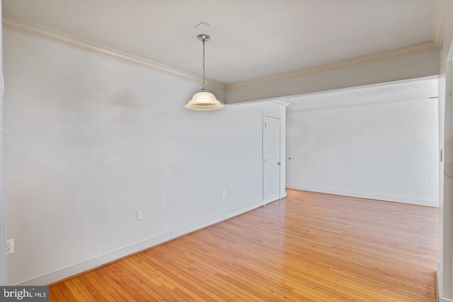 empty room with hardwood / wood-style flooring and ornamental molding