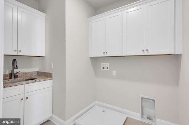 laundry area featuring cabinet space, baseboards, washer hookup, and a sink