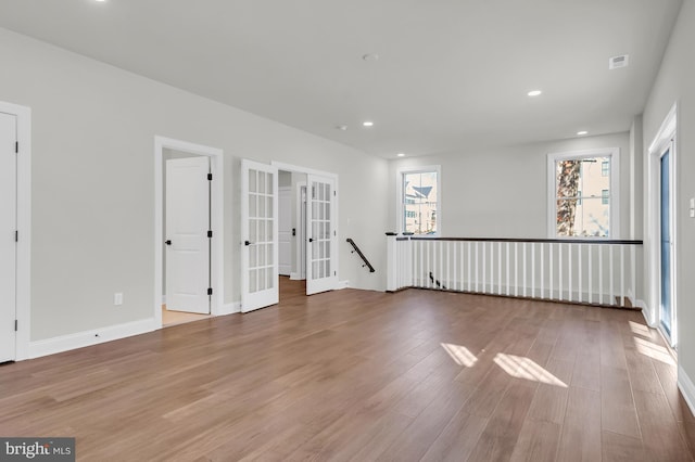 spare room with baseboards, french doors, wood finished floors, and recessed lighting