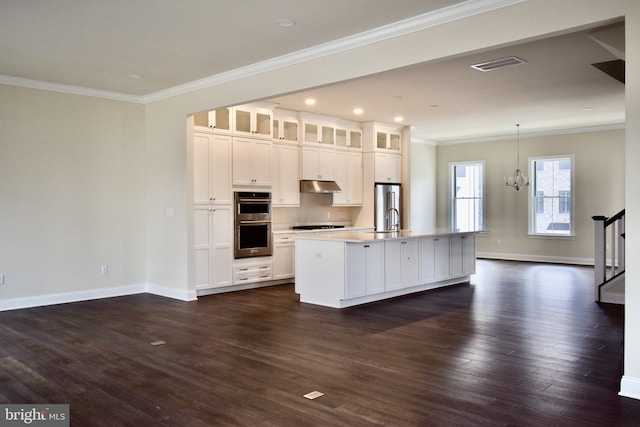 714 Walkers Mill Ln, Wilmington, DE 19807 - kitchen featuring under cabinet range hood, crown molding, appliances with stainless steel finishes, a center island with sink, and white cabinetry