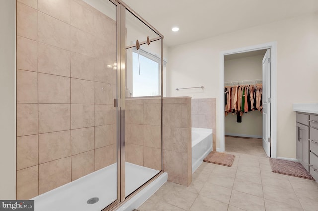 bathroom with tile patterned floors, vanity, and shower with separate bathtub