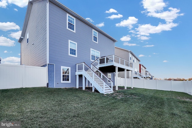 rear view of property featuring a lawn and a wooden deck