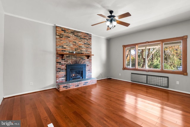 unfurnished living room with a fireplace, hardwood / wood-style floors, ceiling fan, and ornamental molding