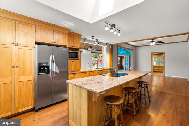 kitchen featuring a wealth of natural light, ceiling fan, appliances with stainless steel finishes, and light hardwood / wood-style flooring