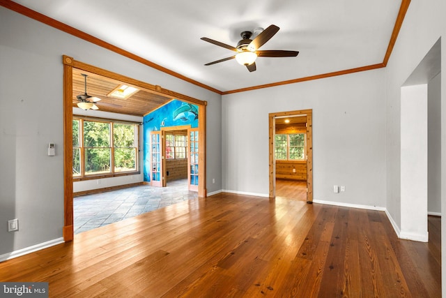 unfurnished living room with wood-type flooring, ornamental molding, and a healthy amount of sunlight