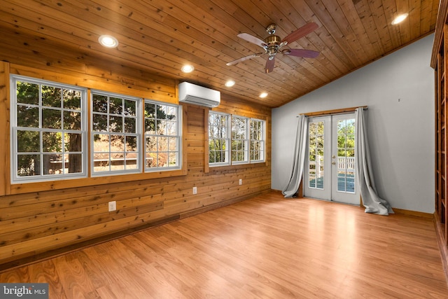 spare room featuring a wall mounted AC, wood ceiling, vaulted ceiling, and light hardwood / wood-style floors