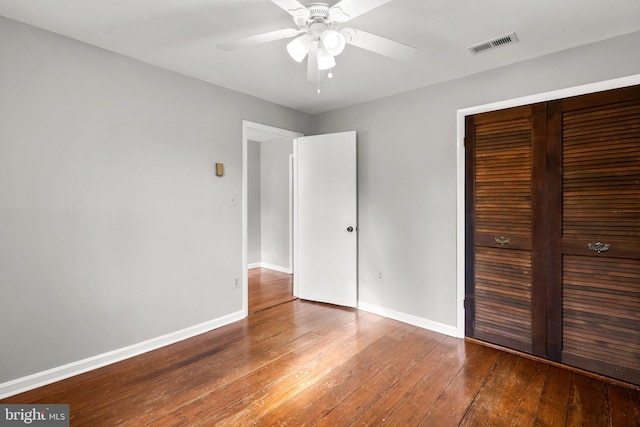 unfurnished bedroom featuring hardwood / wood-style floors, a closet, and ceiling fan