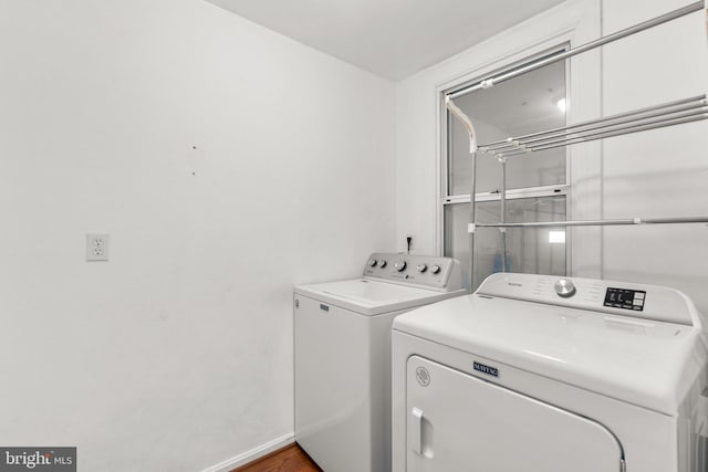 clothes washing area featuring washer and clothes dryer and hardwood / wood-style flooring