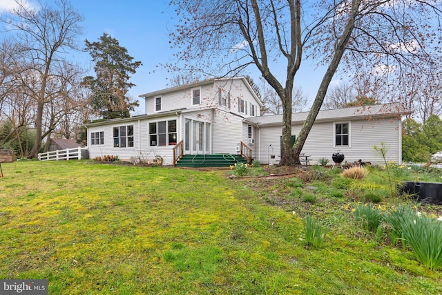 rear view of property featuring a yard