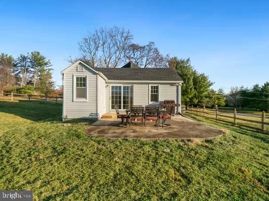 rear view of house featuring a yard and a patio