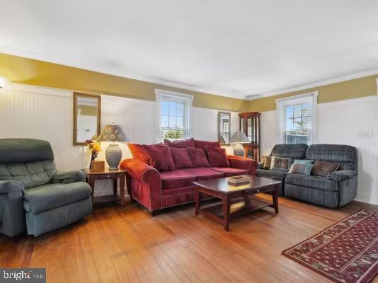 living room featuring wood-type flooring and ornamental molding