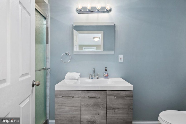 bathroom featuring vanity, toilet, and walk in shower