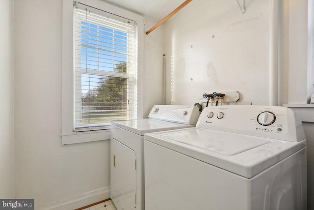 laundry area featuring washer and clothes dryer and light tile patterned flooring