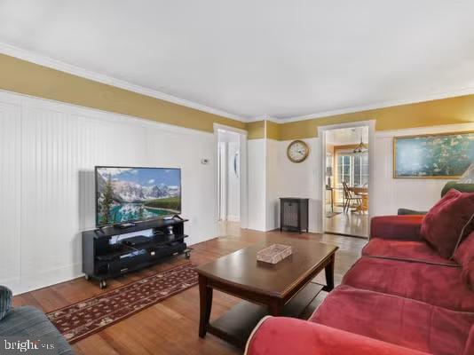 living room featuring hardwood / wood-style flooring and crown molding