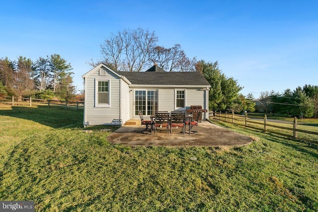 rear view of house with a patio area and a lawn