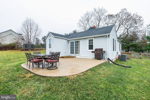 back of property with a trampoline, cooling unit, a patio area, and a lawn