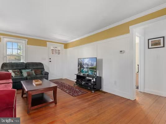 living room with hardwood / wood-style flooring and ornamental molding