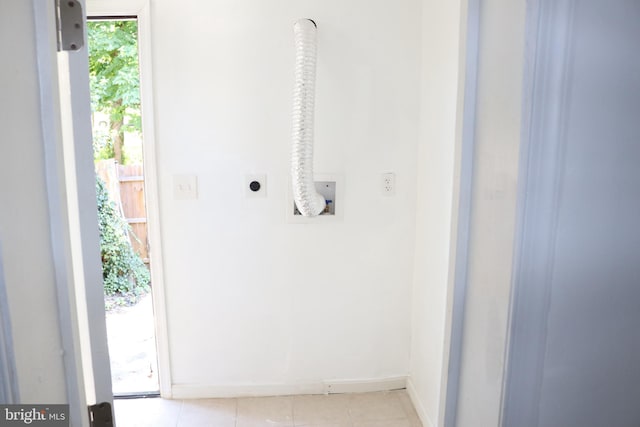 interior space featuring hookup for an electric dryer, light tile patterned floors, and hookup for a washing machine