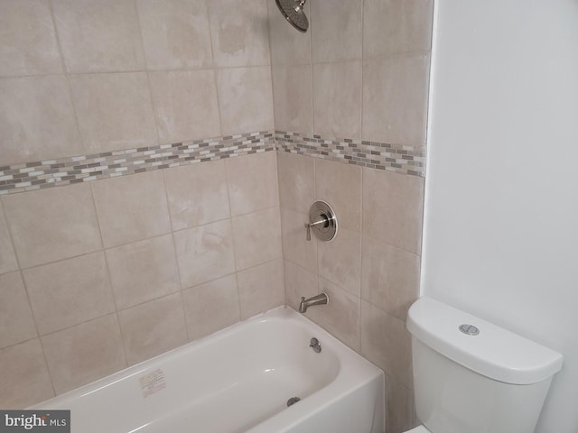 bathroom featuring tiled shower / bath combo and toilet