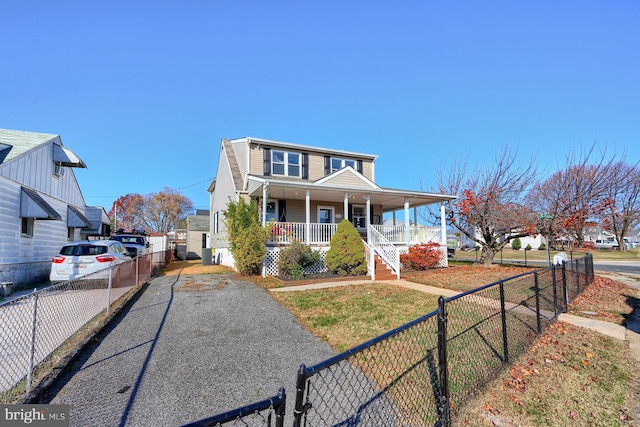 view of front of home with central AC, covered porch, and a front lawn