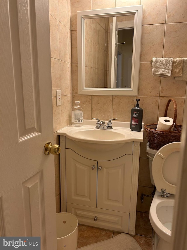 bathroom with backsplash, vanity, toilet, and tile walls