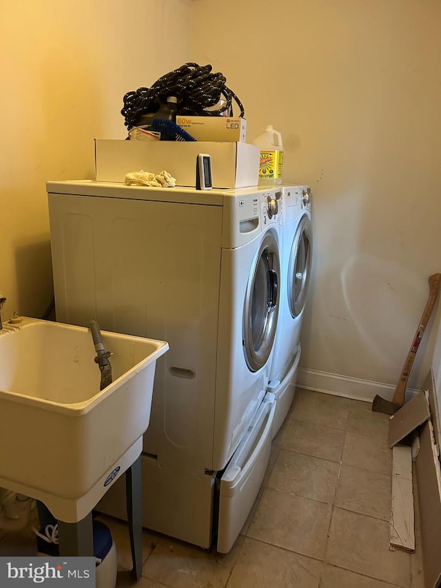 clothes washing area with independent washer and dryer, sink, and light tile patterned flooring