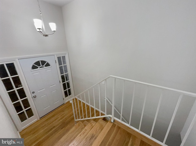 entrance foyer with an inviting chandelier and hardwood / wood-style flooring